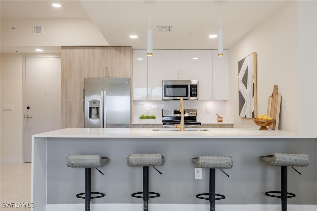 a kitchen with refrigerator and chairs