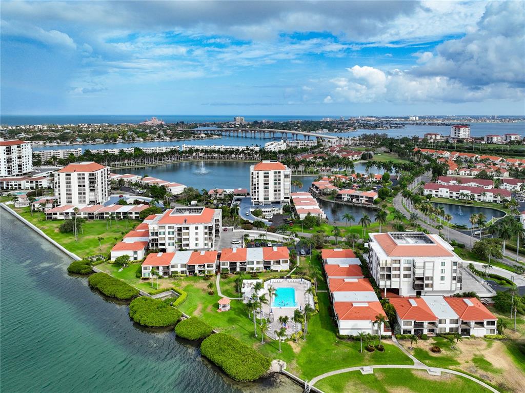 an aerial view of a city with lots of residential buildings ocean and mountain view in back