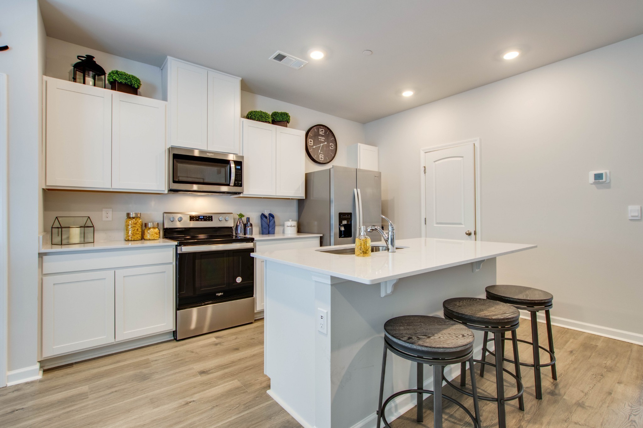 a kitchen with stainless steel appliances a stove a sink a microwave and cabinets