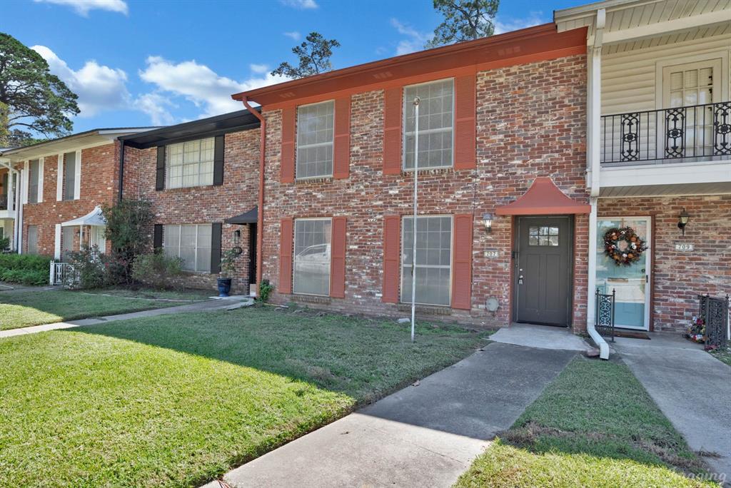 front view of a brick house with a yard