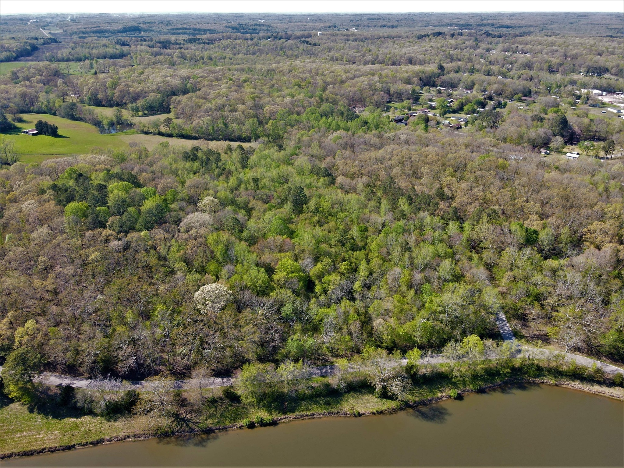 an aerial view of field with trees