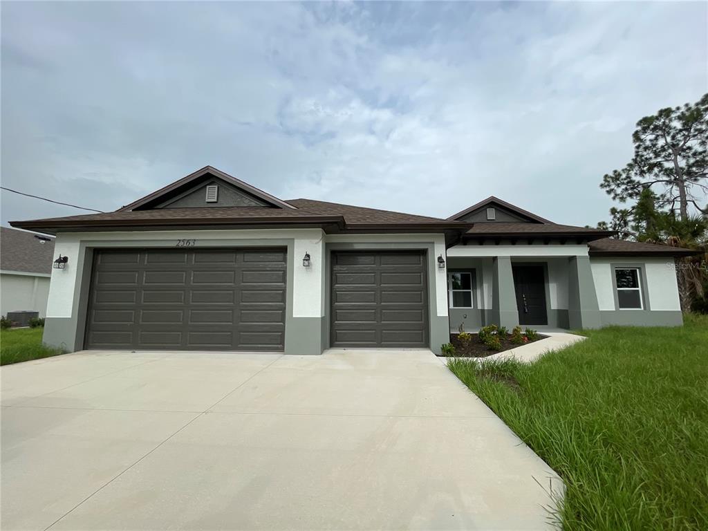 a front view of a house with a yard and garage