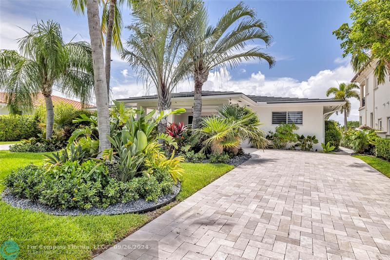 a front view of a house with a yard and potted plants