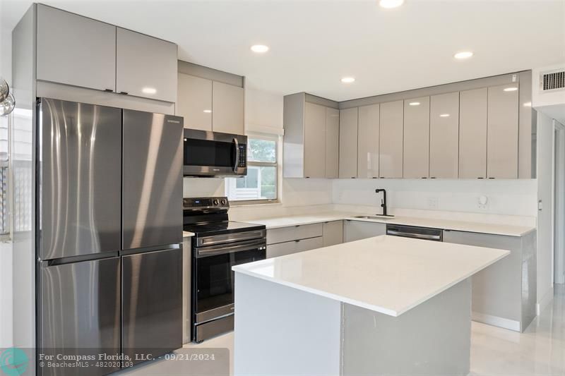 a kitchen with stainless steel appliances a refrigerator sink and microwave