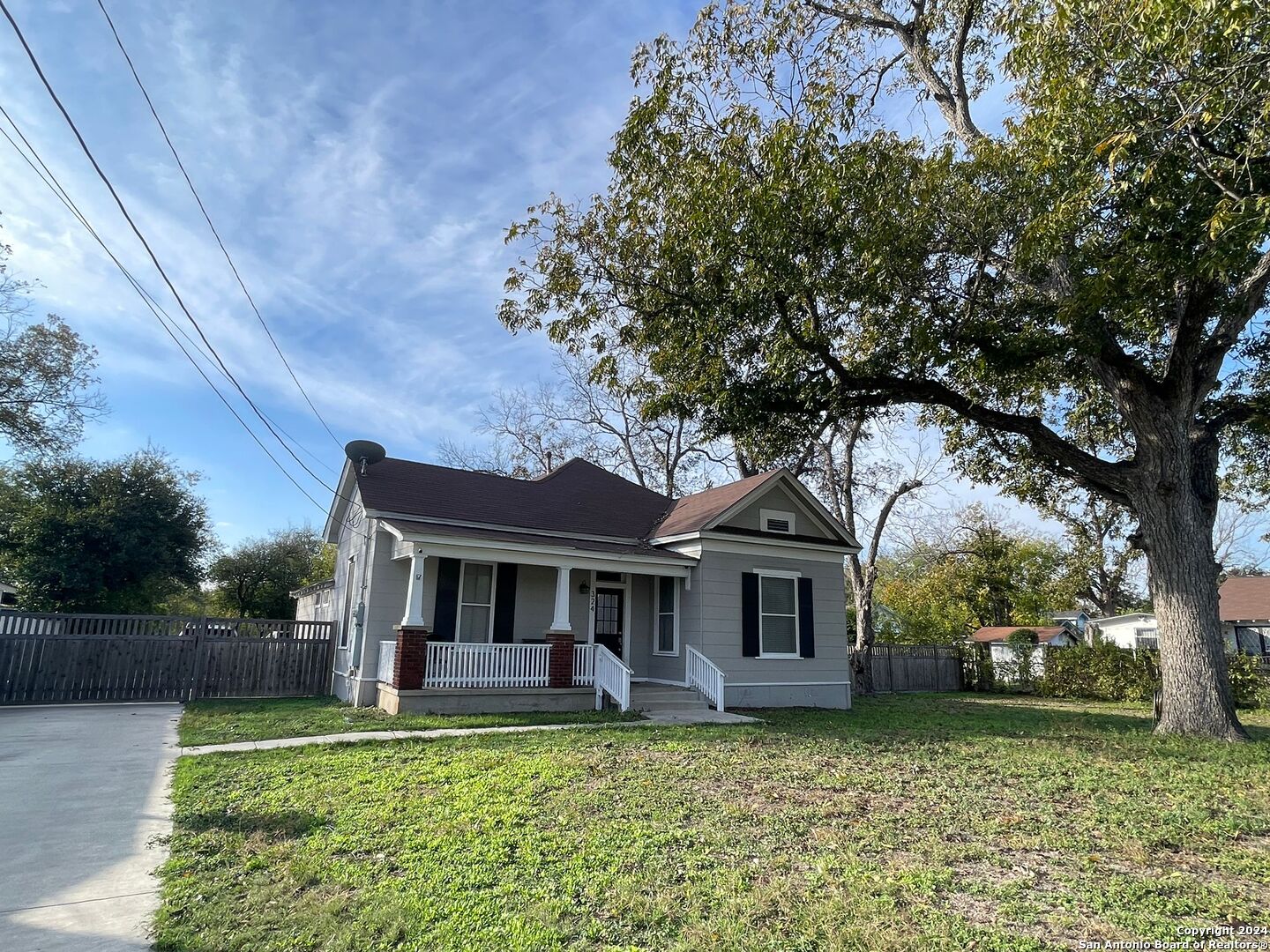 a front view of a house with a garden and trees