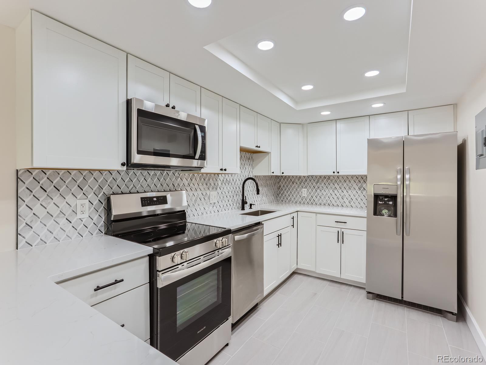 a kitchen with stainless steel appliances granite countertop a stove a sink and a microwave