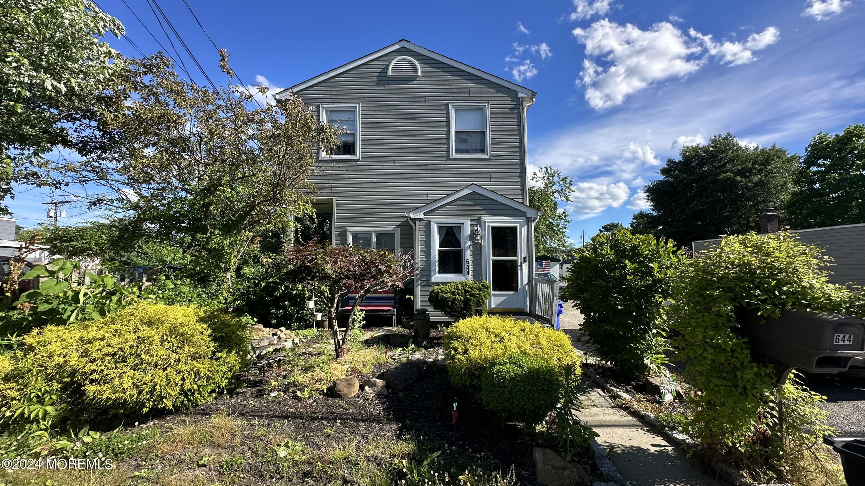 a front view of a house with a yard and potted plants