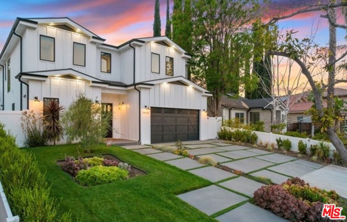 a front view of a house with a garden and plants