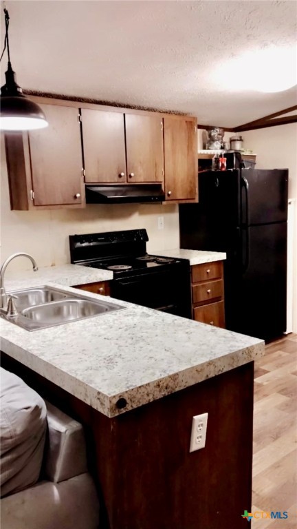 a kitchen with granite countertop a refrigerator a sink and wooden cabinets