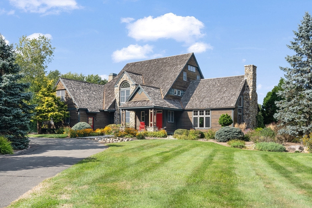 a front view of a house with garden and trees