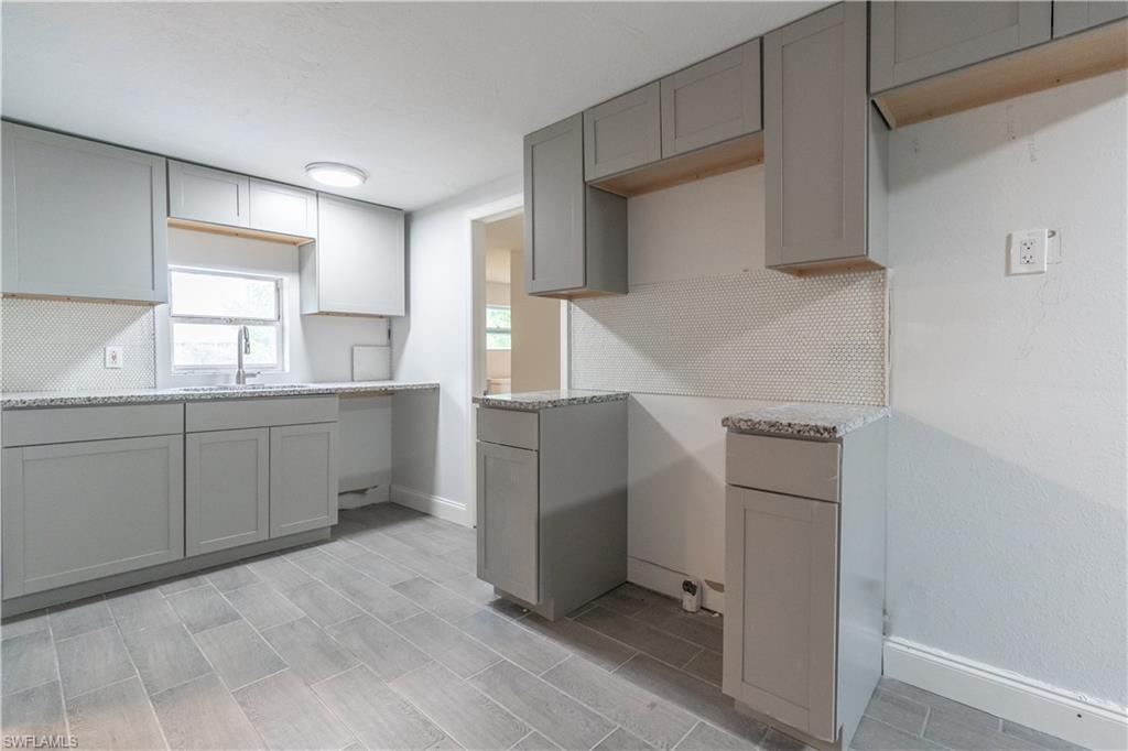 Kitchen with gray cabinetry and backsplash