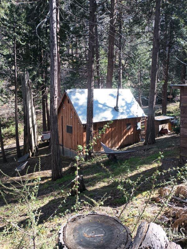 a backyard of a house with barbeque oven and trees