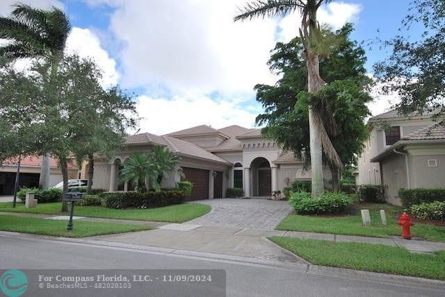 a front view of a house with a yard and palm trees