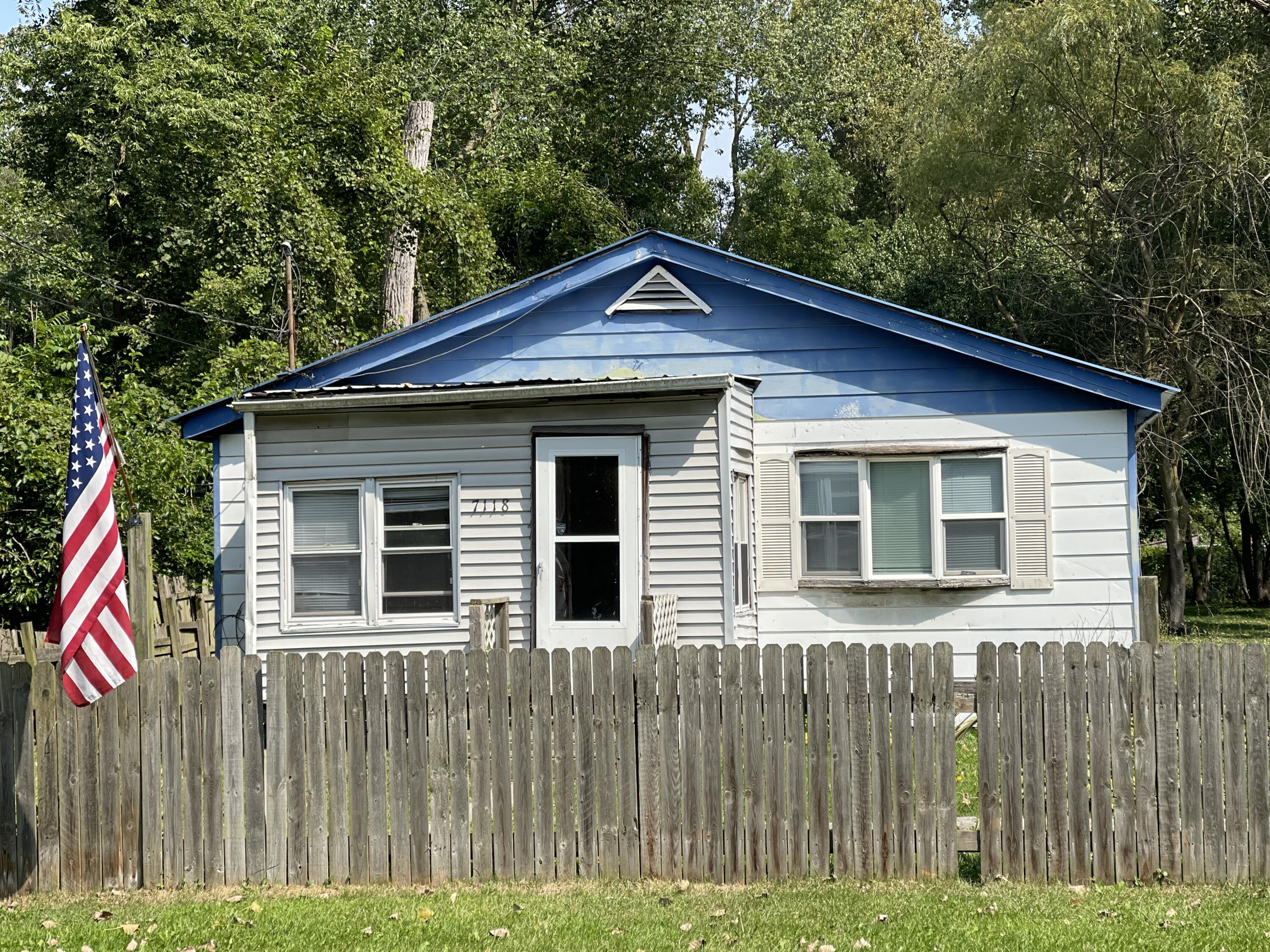 a view of a house with a small yard and wooden fence