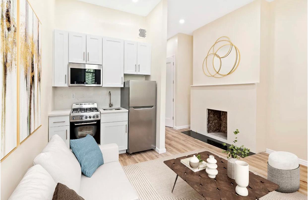 a kitchen with stainless steel appliances a stove refrigerator and a fireplace with wooden floor