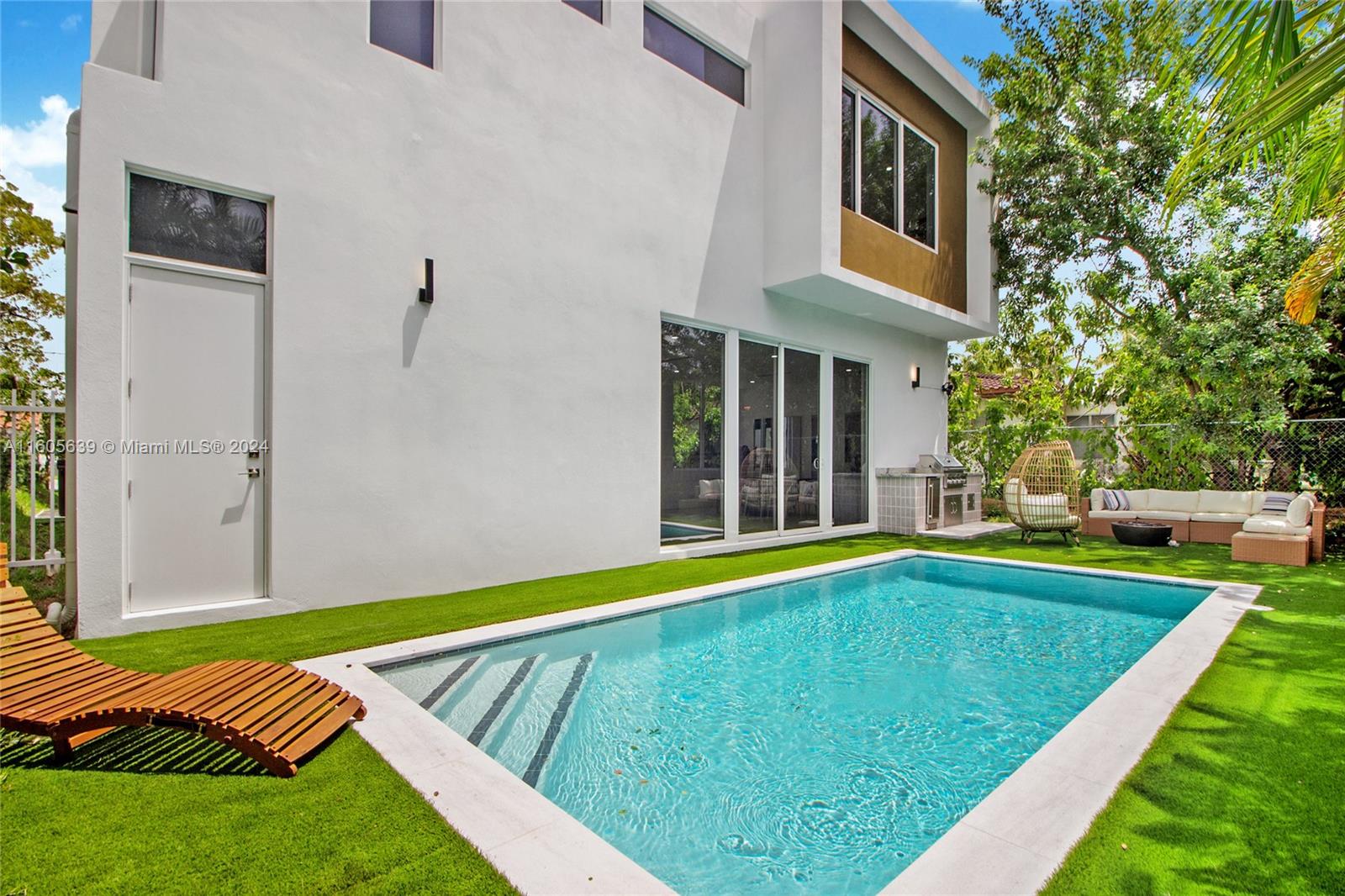 a view of an house with backyard and swimming pool