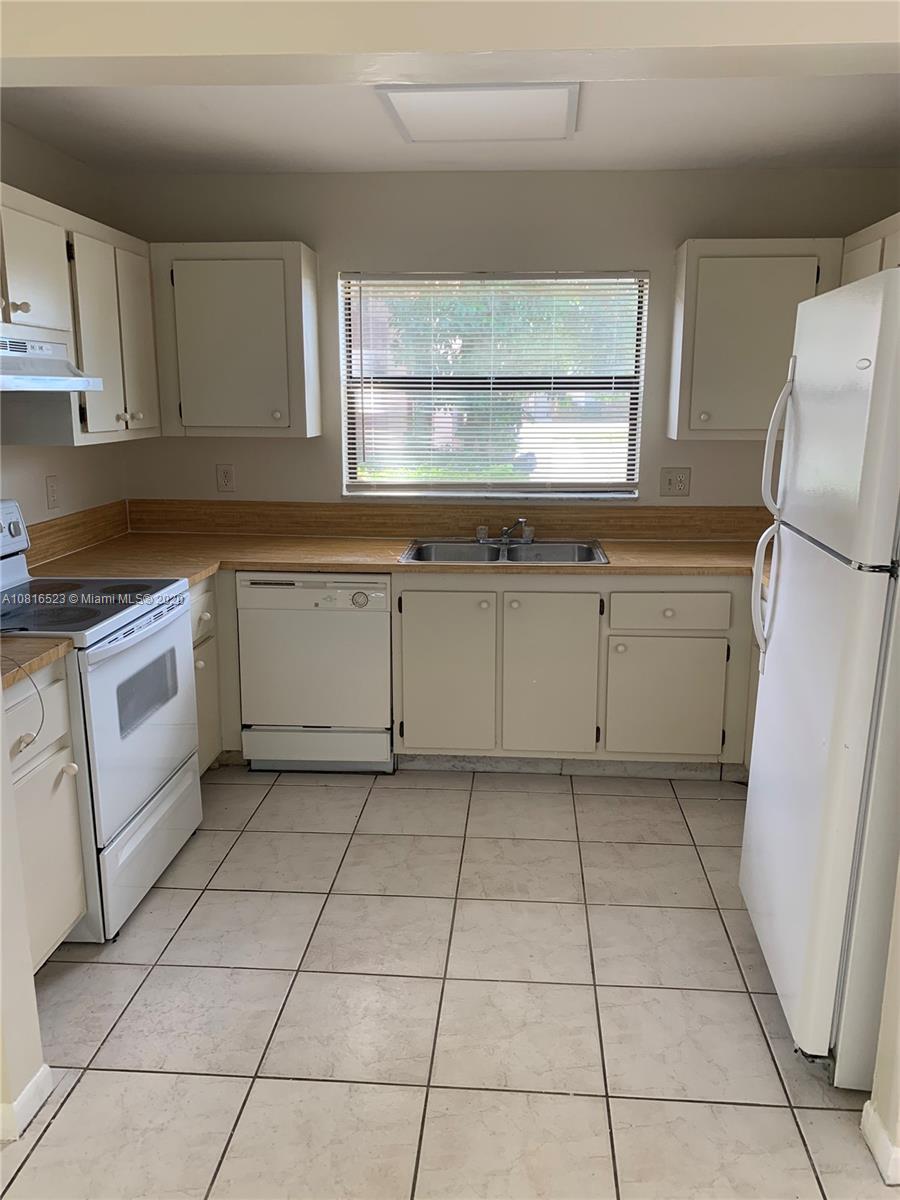 a kitchen with a stove a sink and a refrigerator