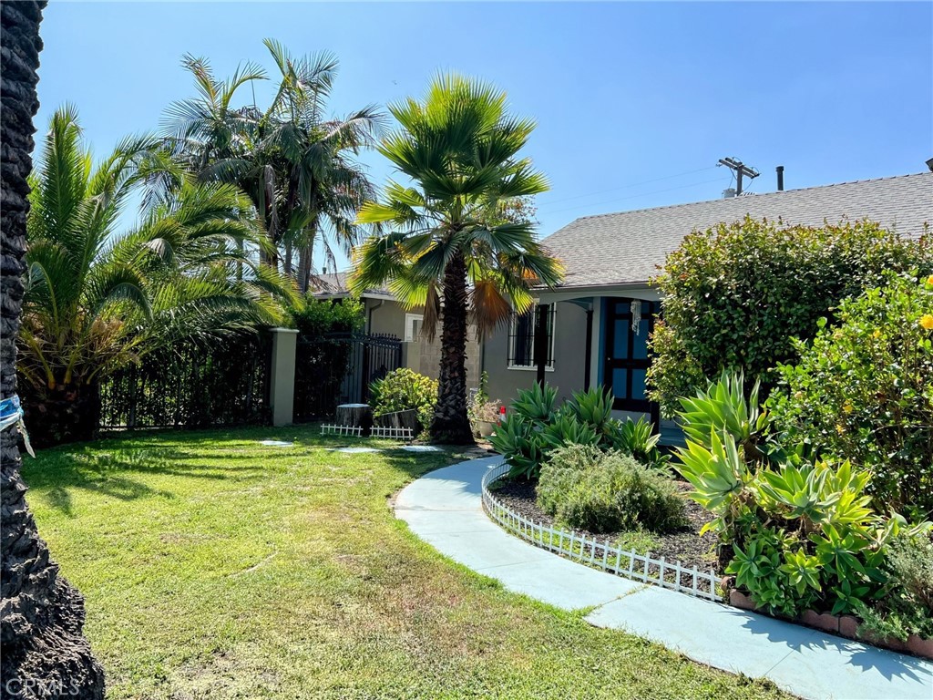 a view of a house with a yard and potted plants