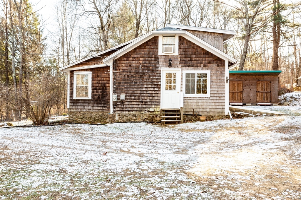 a front view of a house with a yard covered in snow