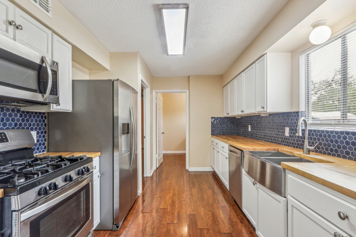 a kitchen with stainless steel appliances a stove a sink and a refrigerator