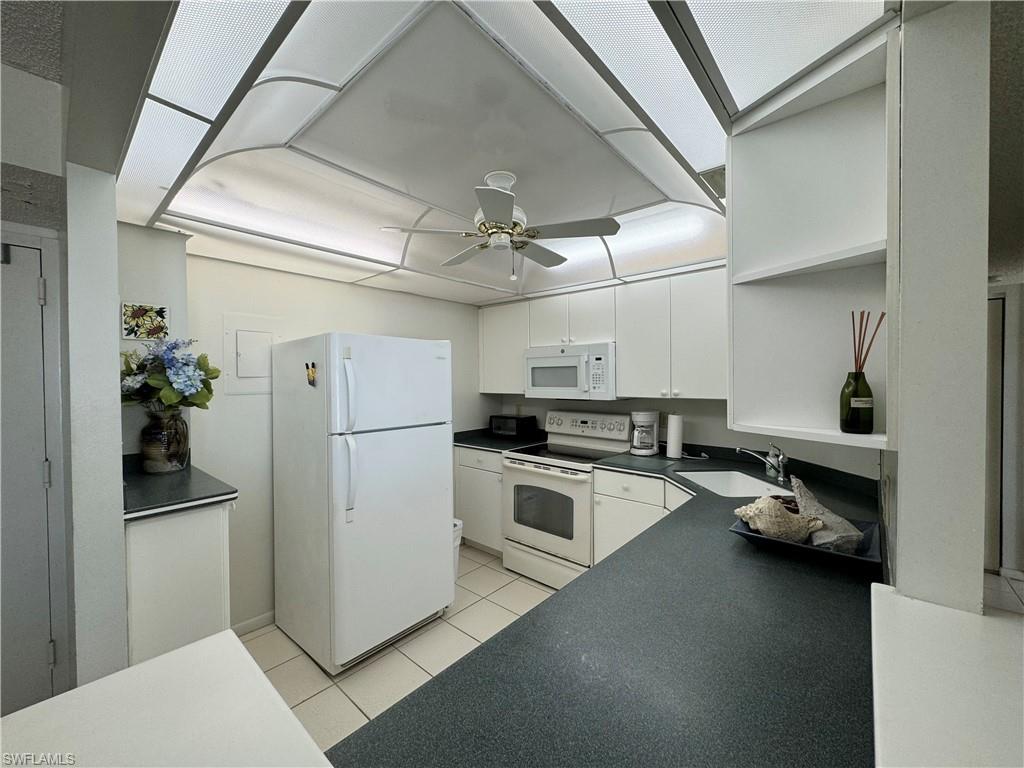 a kitchen with a sink stainless steel appliances and white cabinets