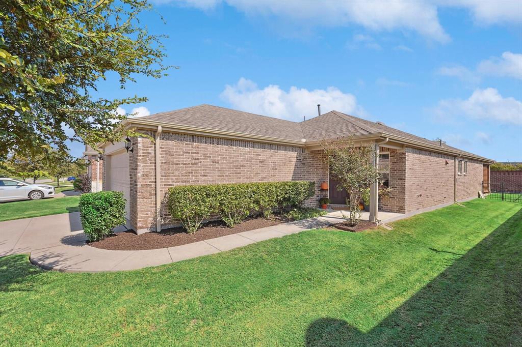 View of property exterior with a garage and a lawn