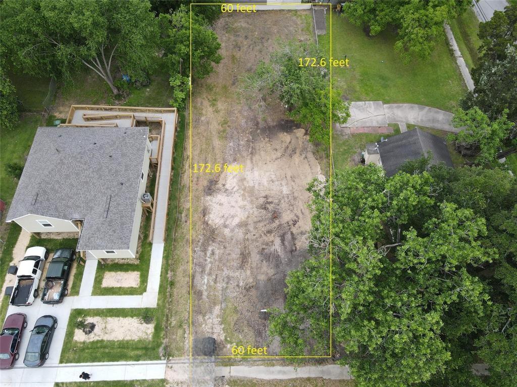 an aerial view of a house with a yard and large tree