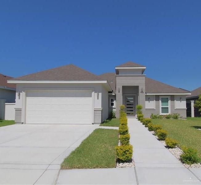 View of front of house featuring a garage and a front lawn