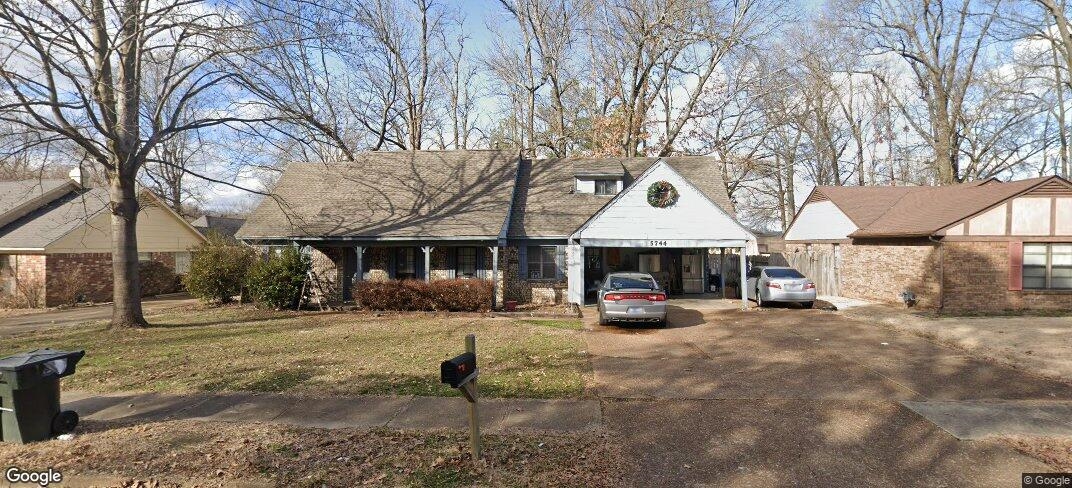 a view of a house with a yard and trees