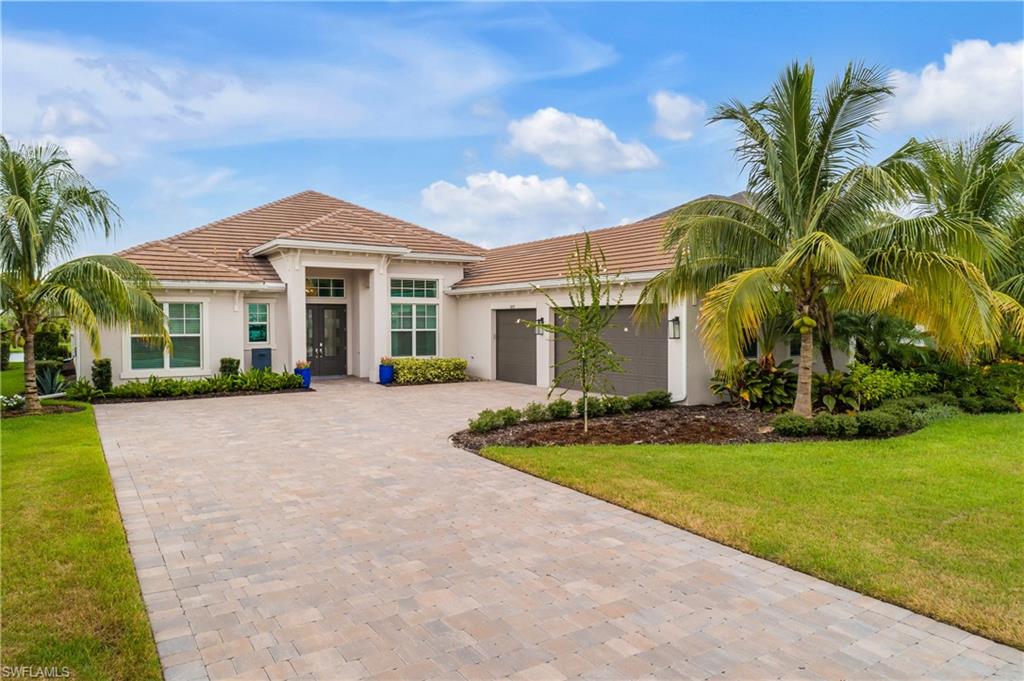 Mediterranean / spanish house featuring a garage and a front yard