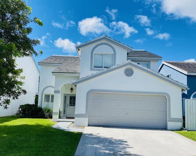 a front view of a house with a garden and yard