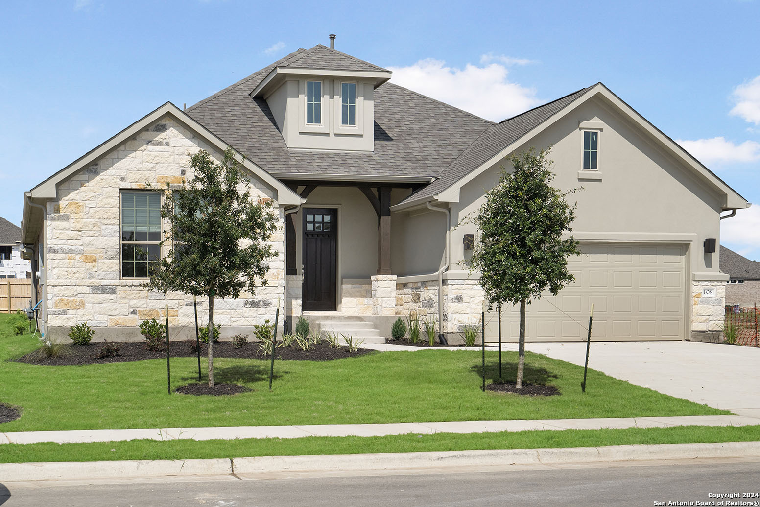 a front view of a house with a garden and plants