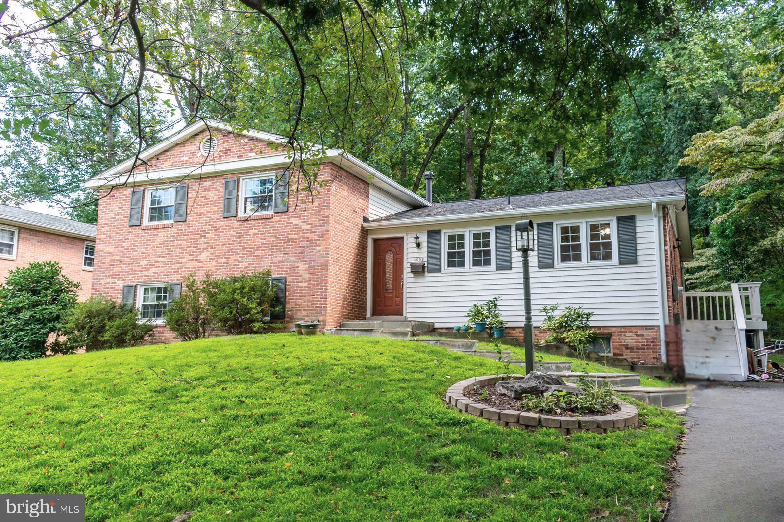 a front view of a house with a yard and green space