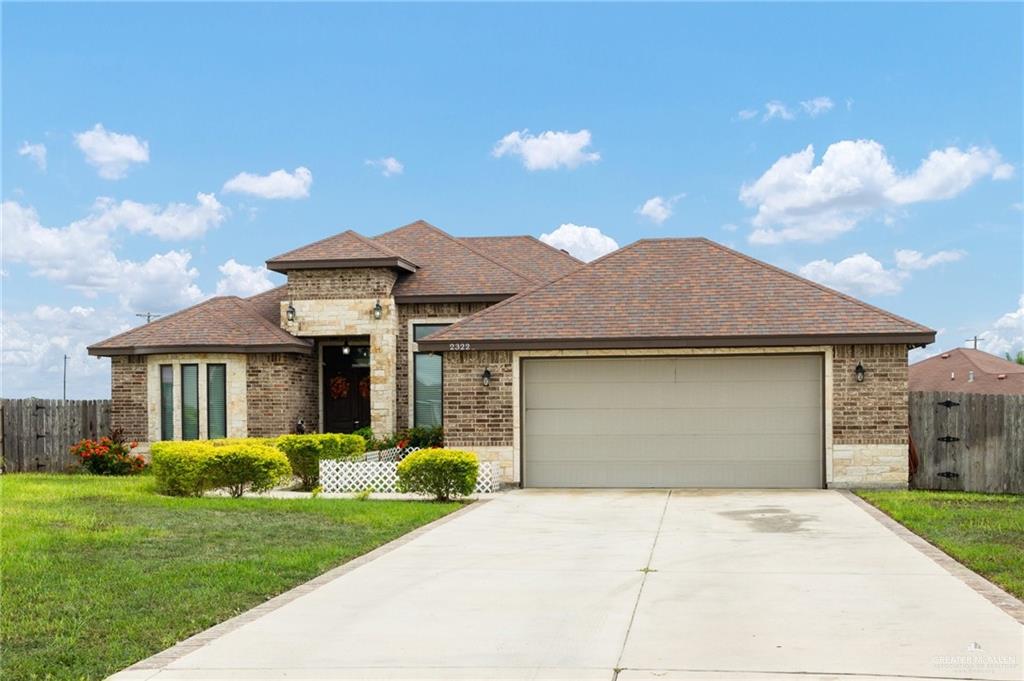 a front view of a house with a garden and yard