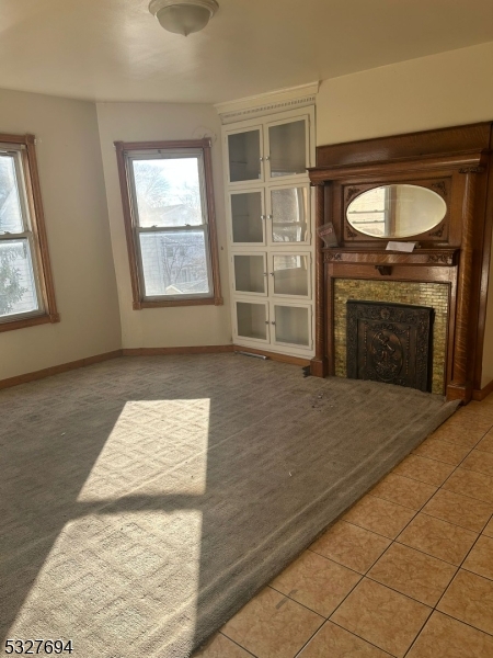 an empty room with windows cabinet and fireplace