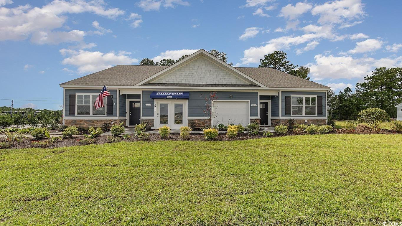 Craftsman-style home with a front lawn and a garag