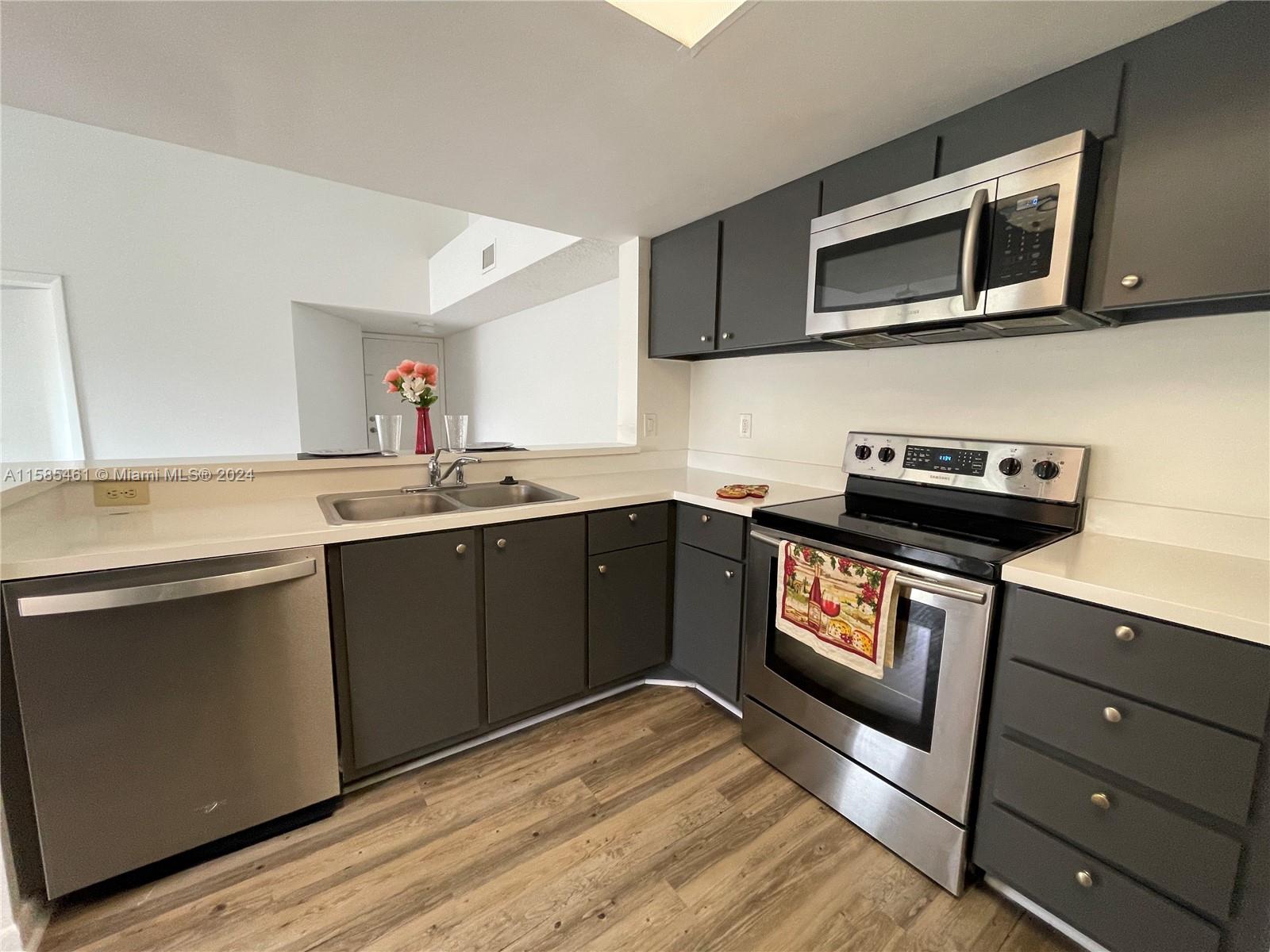 a kitchen with a sink a microwave and cabinets