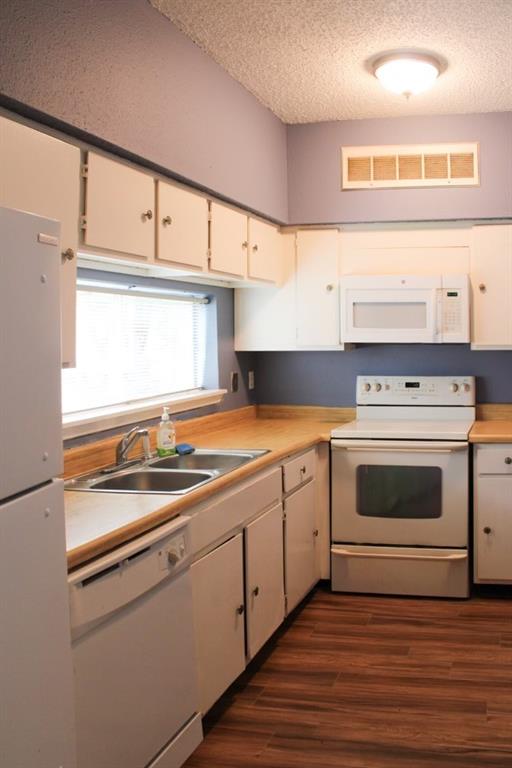 a kitchen with granite countertop white cabinets and white appliances