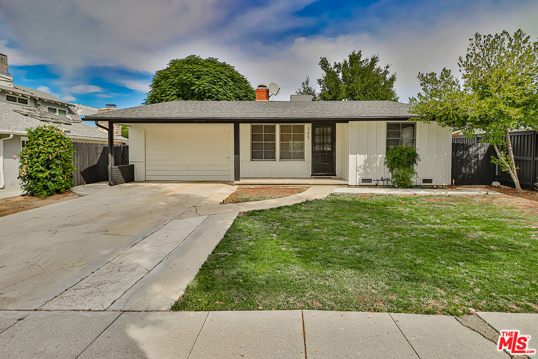 a front view of a house with a yard and potted plants