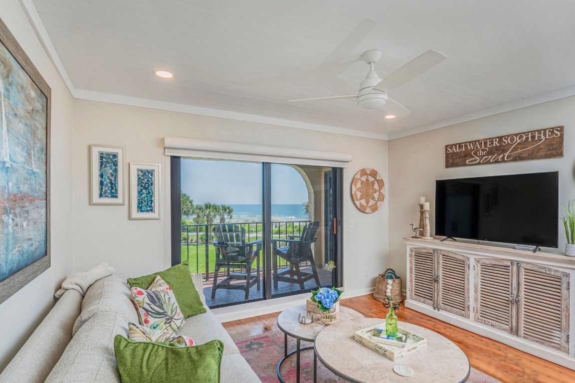 a living room with furniture tv and a floor to ceiling window