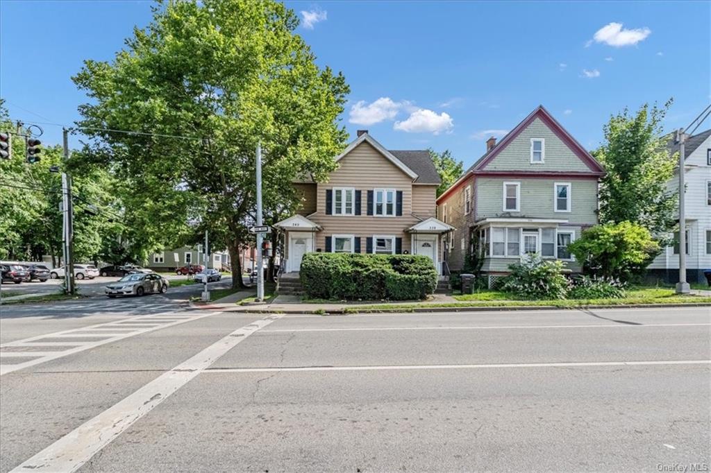 a view of house with street next to a road