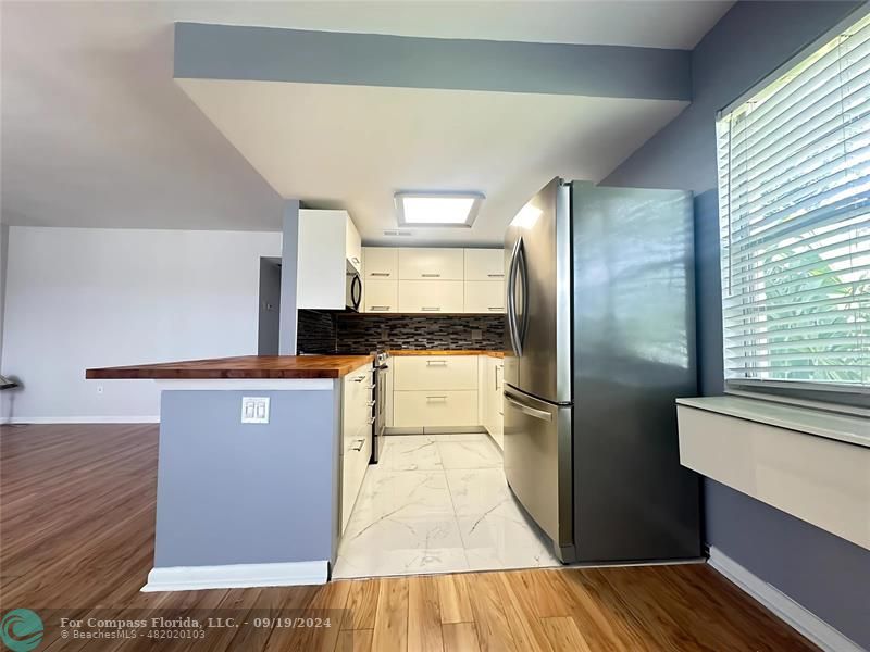 a kitchen with stainless steel appliances granite countertop a refrigerator and a stove