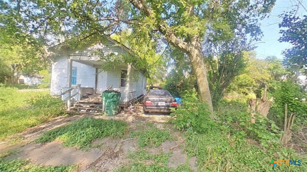 a view of a chair and table in backyard of the house