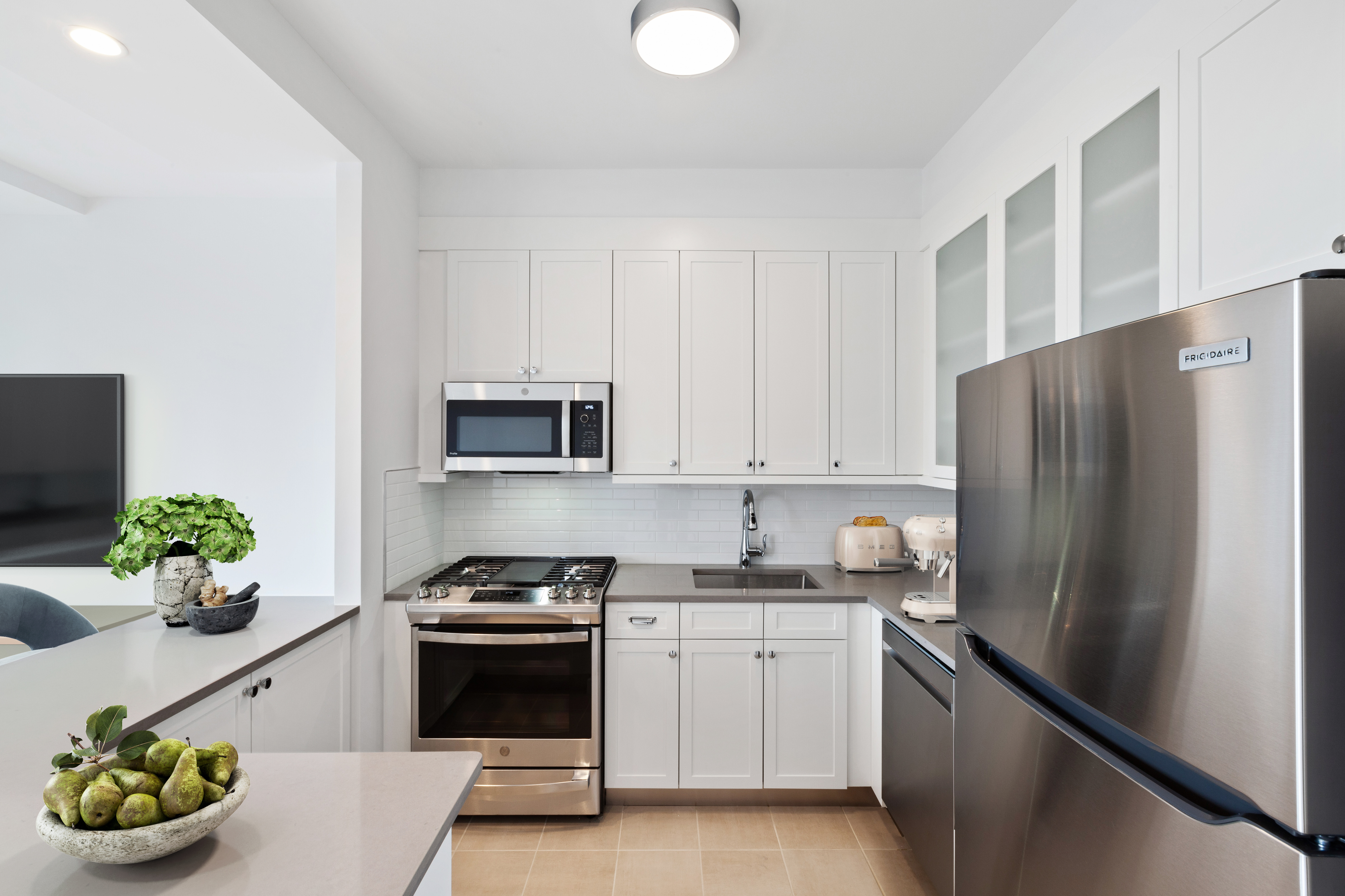 a kitchen with stainless steel appliances a refrigerator sink and white cabinets