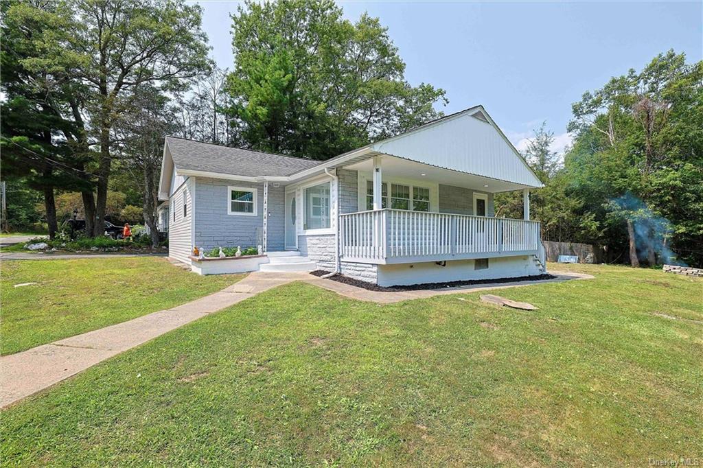 View of front of property with a front lawn and covered porch