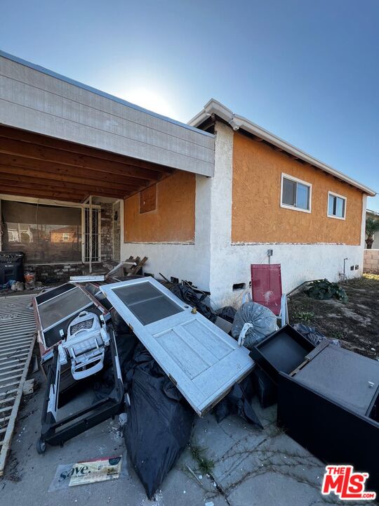 a backyard of a house with barbeque oven table and chairs