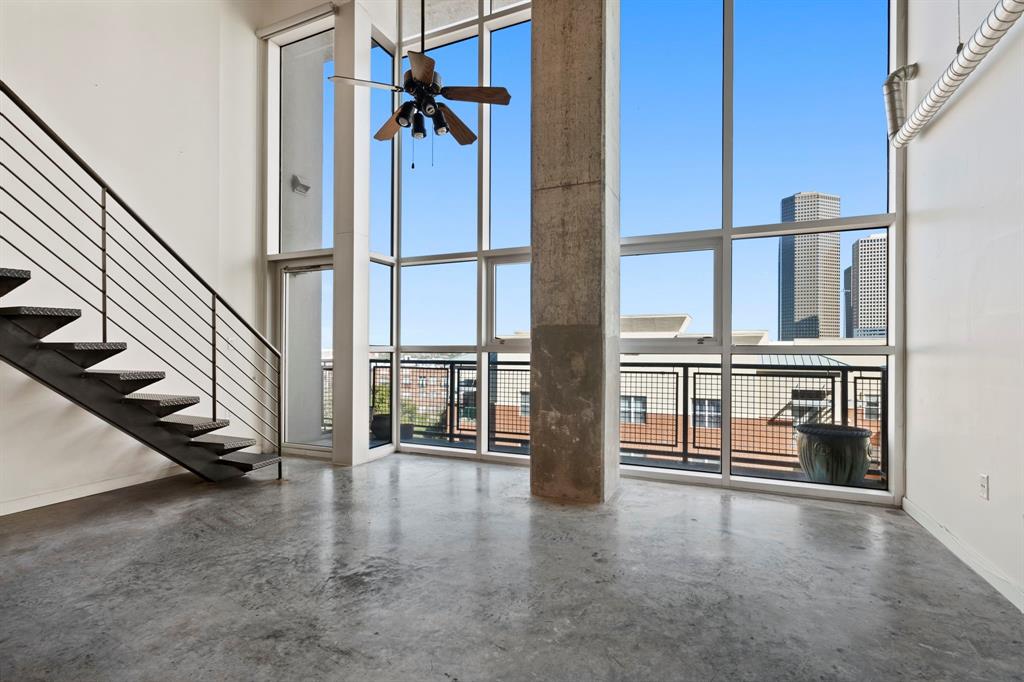 wooden floor with a view of staircase and white walls