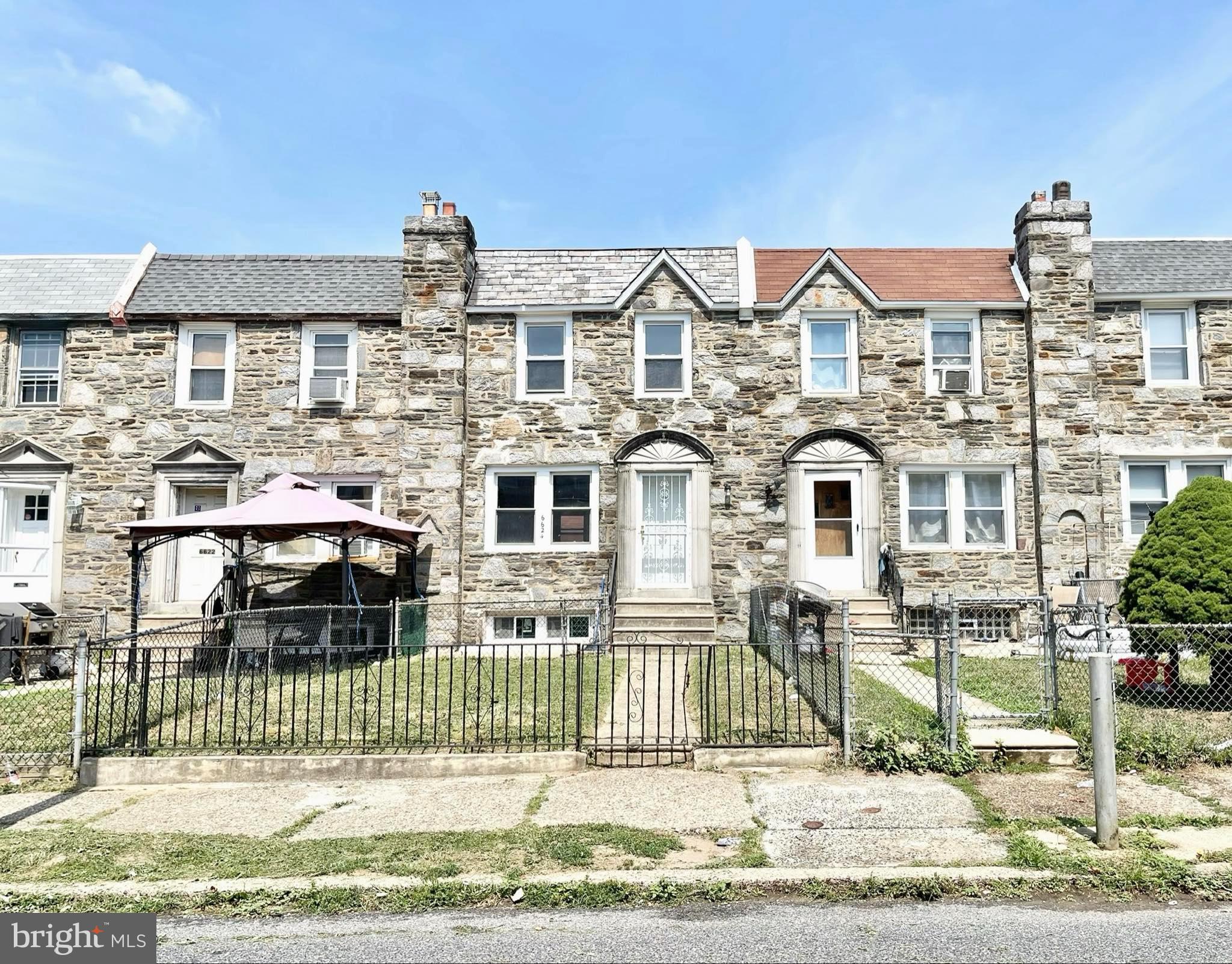 a front view of a house with a wrought fence