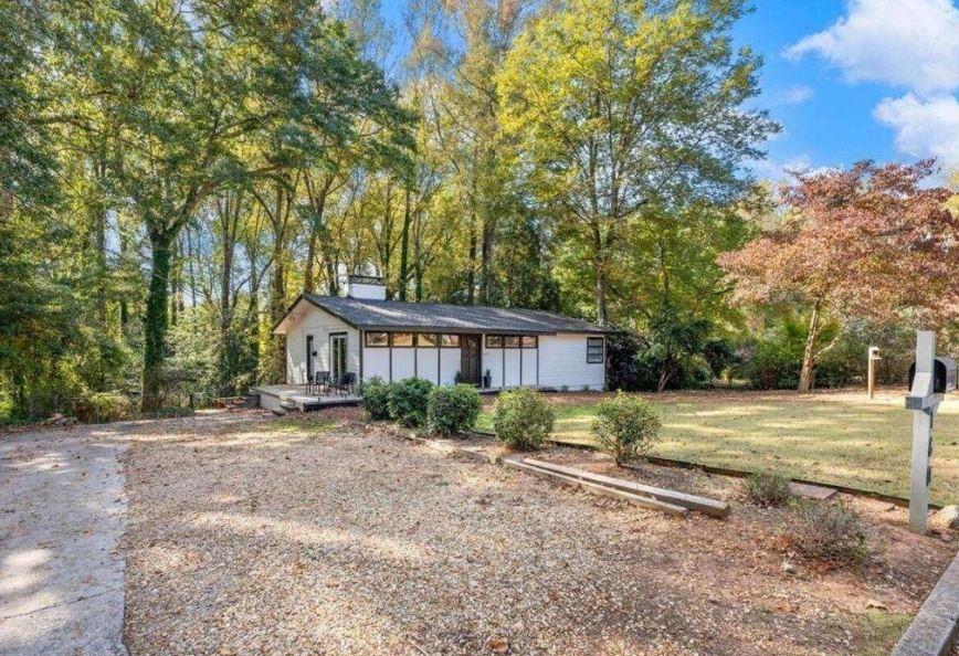 a big house with large trees and a wooden fence