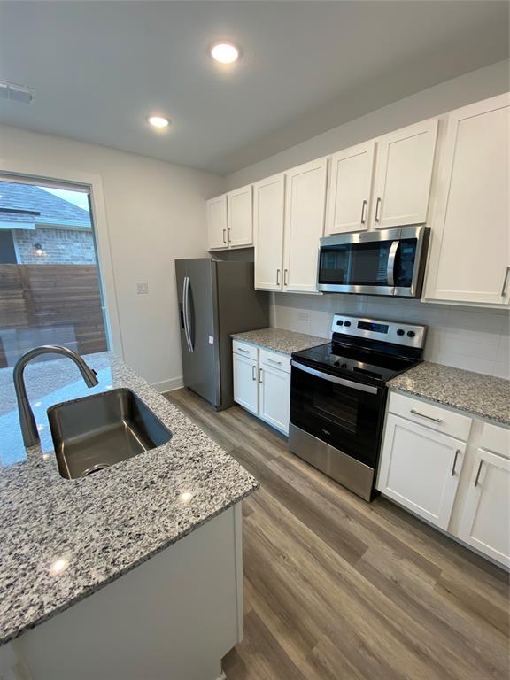 a kitchen with kitchen island granite countertop a stove microwave and refrigerator